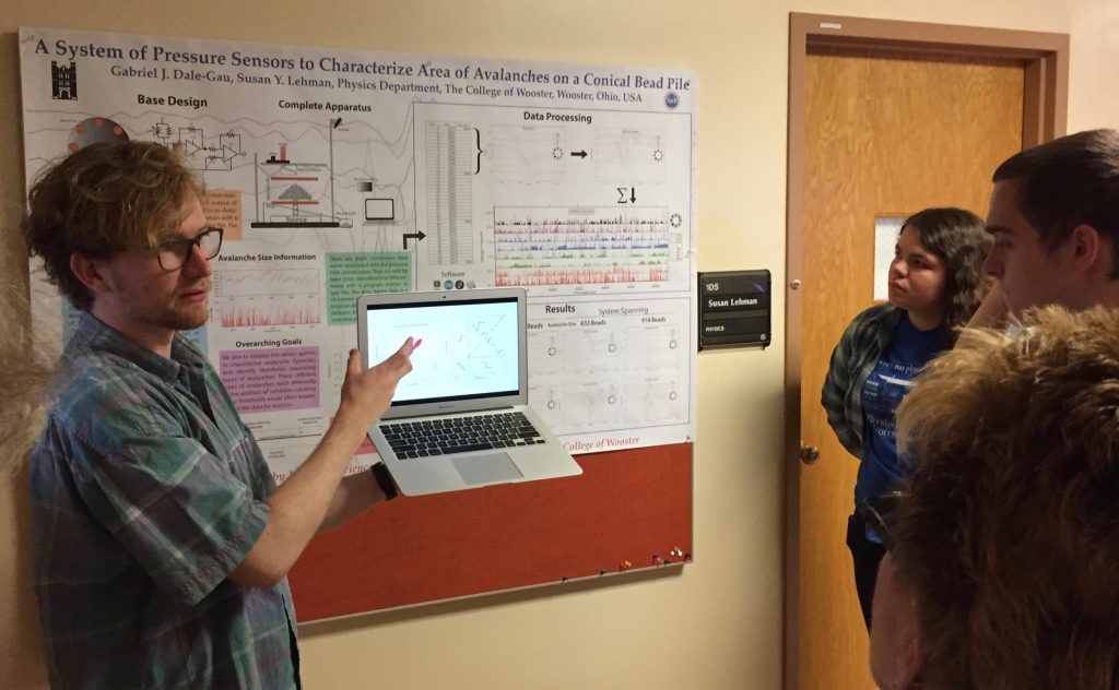 Gabe Dale-Gau stands in front of his research poster